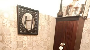 A bathroom with a sink, mirror, and dark wooden cabinet with decorative hearts. - Apartment 'Civico 5' with Wi-Fi and Air Conditioning (Lamezia Terme)