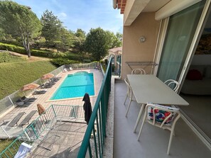 A balcony with a pool, outdoor furniture, and a table. - Vrbo Property (Gréoux-les-Bains)