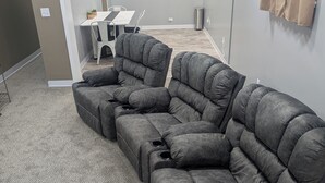 Un sofá modular en una sala de estar con una mesa de comedor y sillas al fondo.