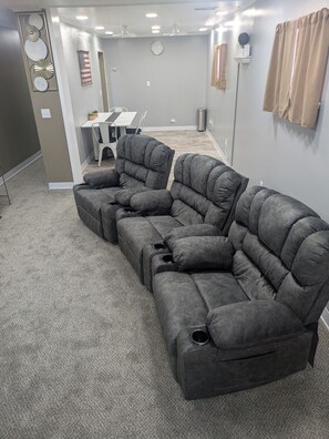 A sectional sofa in a living room with a dining table and chairs in the background. - Toluca Laundromat Hotel, Entire Rental Unit. 3 Bedrooms,4 beds. 1 Bath (Toluca)