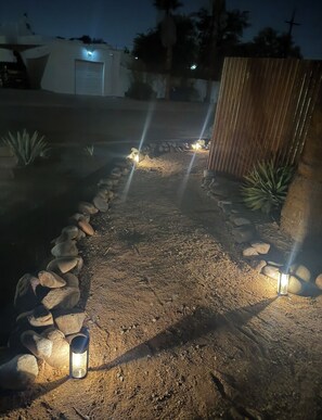A pathway with rocks and plants, leading to a wooden fence. - New Tucson home for travel nurses, grads & professionals, near hospitals" (Tucson)