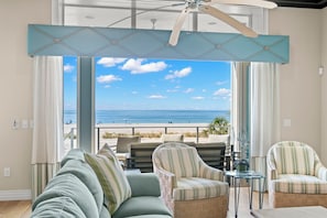 A room with a view of the beach, a ceiling fan, and a seating area with a sofa and chairs. - Treasure Island On the Sand Pool Hot Tub Slps 12 (Treasure Island)