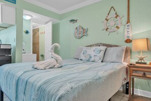 Una camera da letto con un letto, una ruota di timone a muro e un asciugamano sul letto.