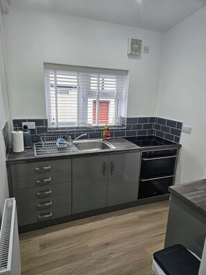 A modern kitchen with a built-in stove, oven, and sink. - Nancys Nook - Whitby (Whitby)