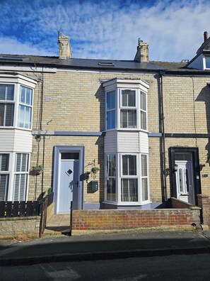 A two-story residential building with a bay window, a front door, and a small garden area. - Salt & Sage - Whitby (Whitby)