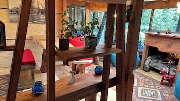 A rustic interior with wooden furniture, a fireplace, and a view of the outdoors.