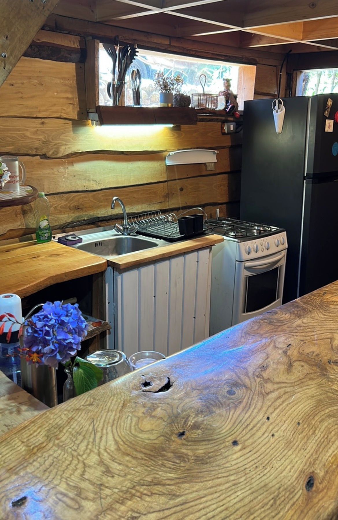 Une cuisine avec un plan de travail en bois, un évier, une cuisinière et un réfrigérateur.