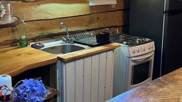 Une cuisine avec un plan de travail en bois, un évier, une cuisinière et un réfrigérateur.