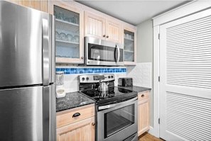 A compact kitchen with a stainless steel refrigerator, a microwave, an oven, and a stove. - Alluring 2BR/2BA With Spectacular Baytowne Fireworks View (Miramar Beach)