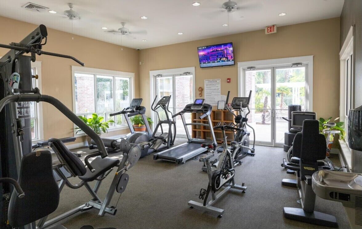 Ein Fitnessstudio mit Laufbändern, Crosstrainern und Krafttrainingsgeräten.