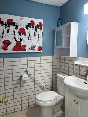 A bathroom with a toilet, sink, and a wall-mounted towel rack. - 1 Bedroom Apartment in Motel, 4 minutes walk to the beach (Saugeen Shores)