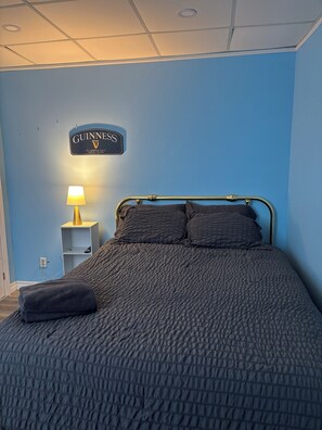 A hotel room with a bed, a nightstand with a lamp, and a sign on the wall. - 1 Bedroom Apartment in Motel, 4 minutes walk to the beach (Saugeen Shores)