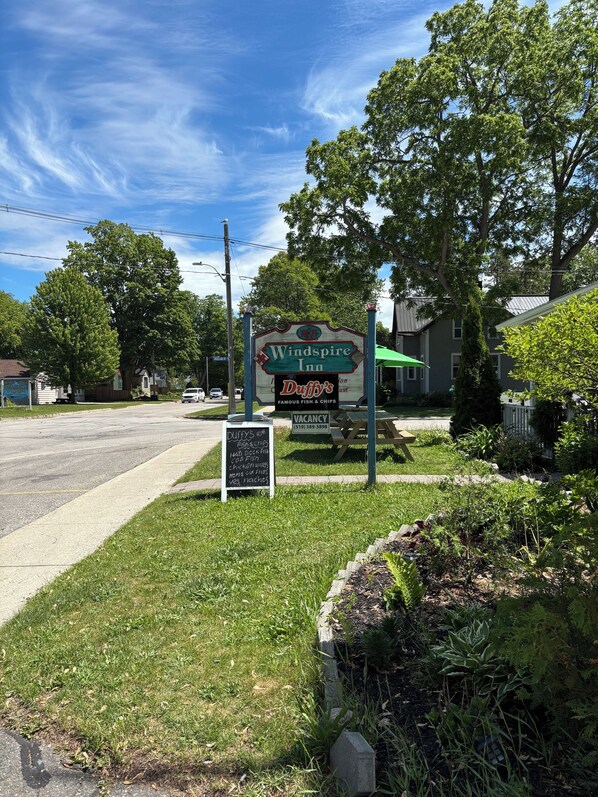 A roadside sign for Windspire Inn with a nearby sign for Duffy's Dishes & Chips.