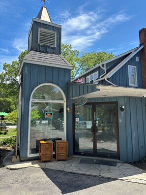 A small building with a sloped roof, a large arched window, and a sign that reads 'WINDSPIRE.' - 1 Bedroom Apartment in Motel, 4 minutes walk to the beach (Saugeen Shores)