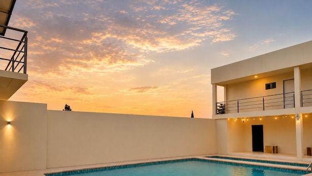 A swimming pool with a clear blue water surface, surrounded by a white tiled deck.