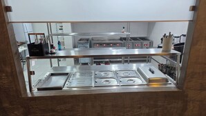A commercial kitchen with stainless steel appliances, including a stove and a sink.