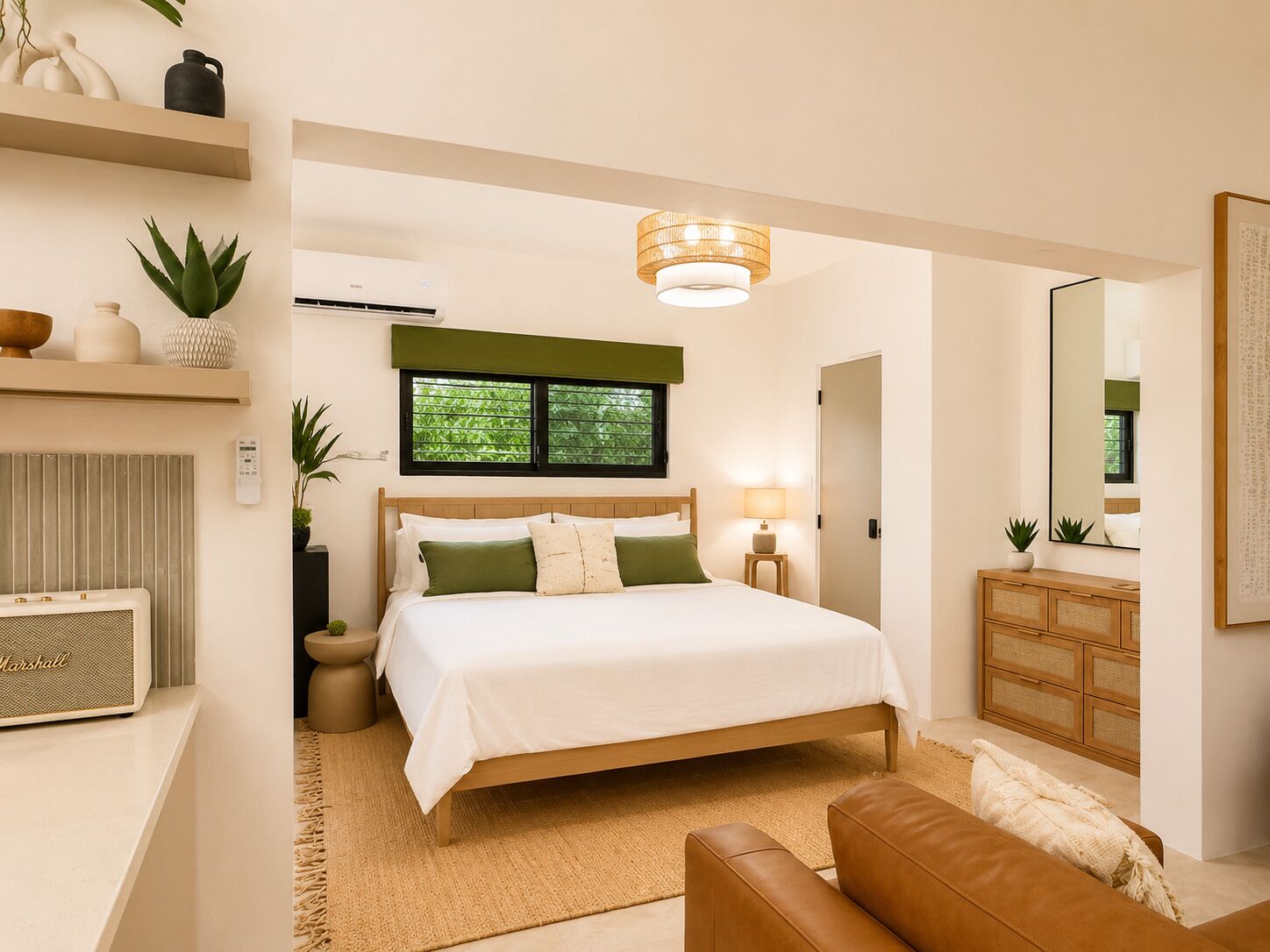 Une chambre à coucher comprenant un lit, une table de chevet, une lampe, une commode, un miroir et une fenêtre avec des stores.