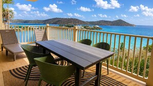 A balcony with a table and chairs, overlooking a coastal view with clear skies. - Panoramic Caribbean views at Villa Orizzonte (St Thomas)
