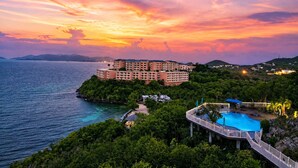 A coastal hotel with multiple buildings, a swimming pool, and lush greenery. - Panoramic Caribbean views at Villa Orizzonte (St Thomas)