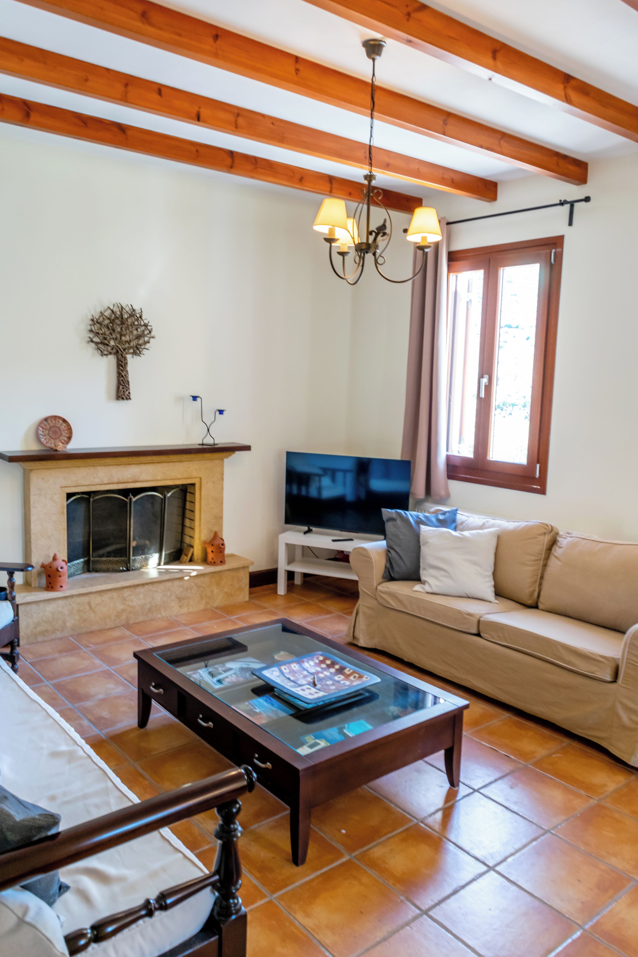 A living room with a fireplace, a sofa, a coffee table, and a television.