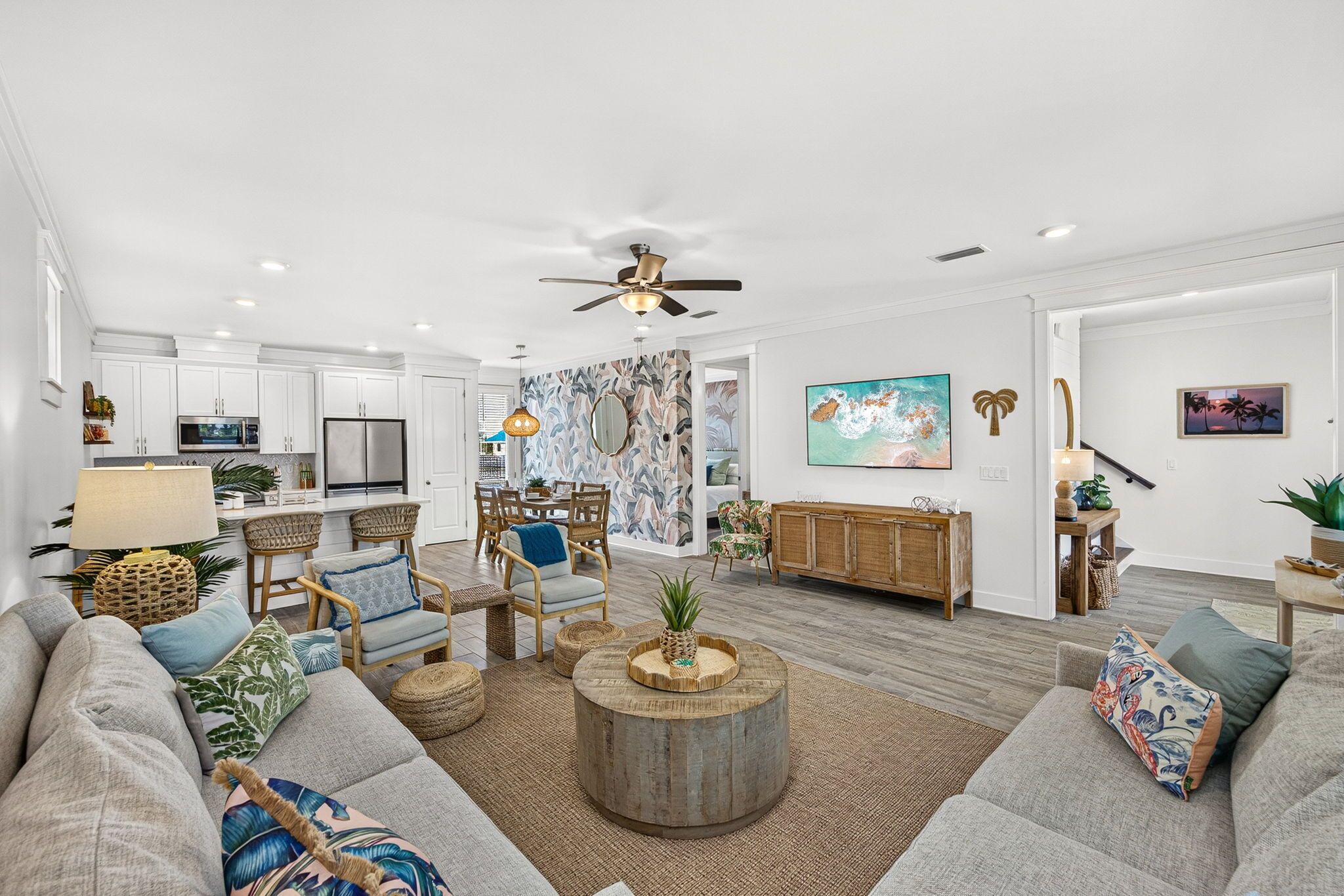 A modern living room with a sofa, chairs, a coffee table, and a dining area with a table and chairs.