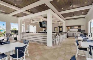A spacious indoor area with a bar and seating arrangements. - Spacious 6-bedroom 5 bathroom house in Champions Gate With Pool & Spa (Four Corners)