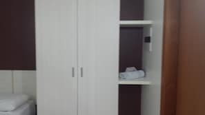 Une chambre avec un placard, une étagère avec des serviettes et des toilettes.