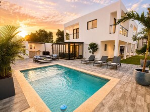 A modern outdoor pool area with a rectangular pool, lounge chairs, and a covered seating area. - Private Pool Villa 3BR Gated 10 Min Downtown (Punta Cana)