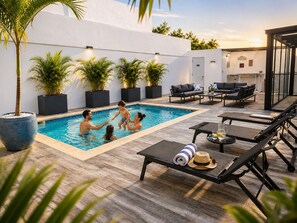 A swimming pool with a tiled deck, surrounded by lounge chairs and a dining area with a table and chairs. - Private Pool Villa 3BR Gated 10 Min Downtown (Punta Cana)