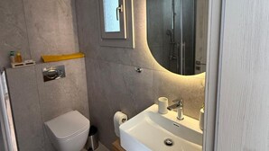 Une salle de bain moderne avec des toilettes, un lavabo et un miroir.