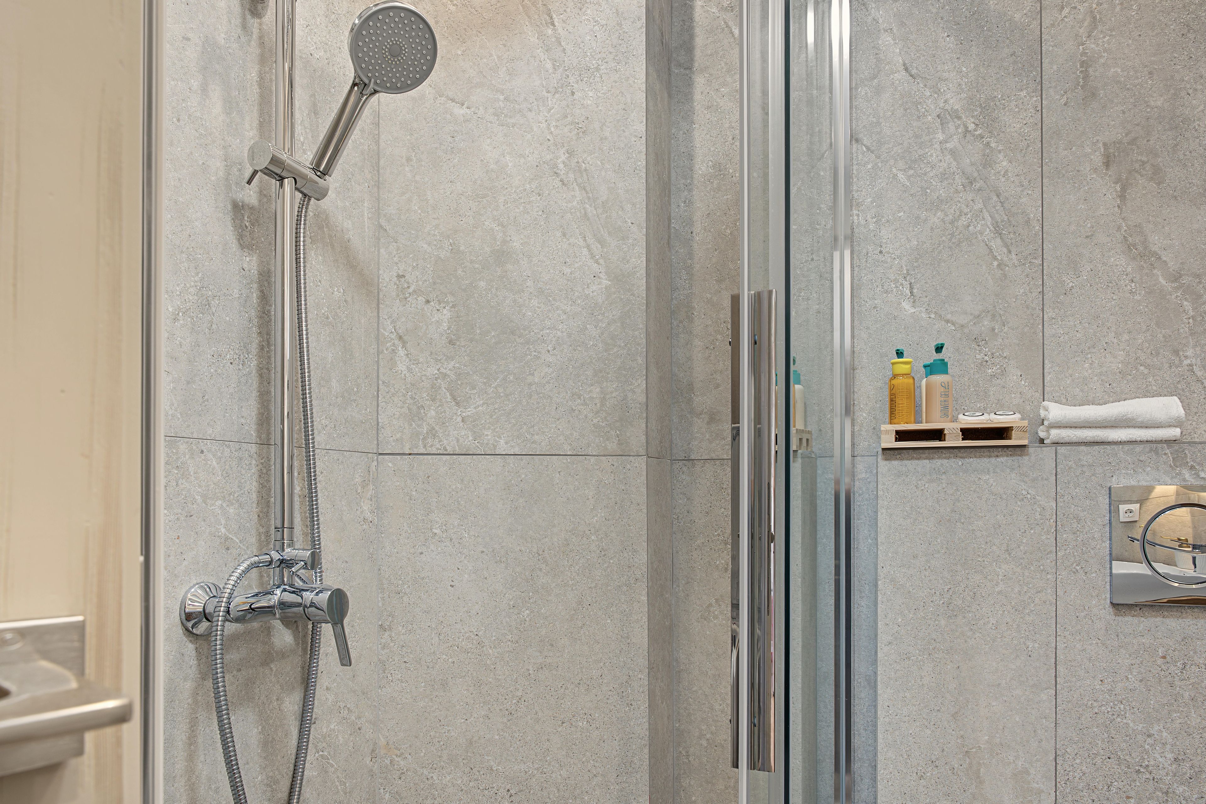 A shower with a handheld showerhead and a wall-mounted rain showerhead.