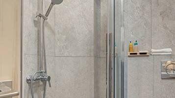 A shower with a handheld showerhead and a wall-mounted rain showerhead.