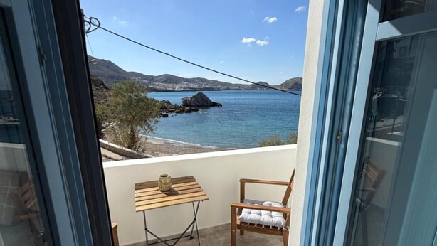 Un balcon donnant sur la côte, avec une table et une chaise.