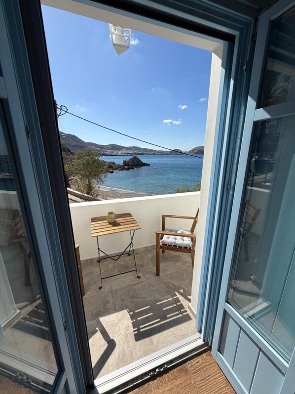 Un balcone con vista sulla costa, un tavolo e una sedia.
