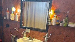 Une salle de bain avec un lavabo, des toilettes et un miroir.