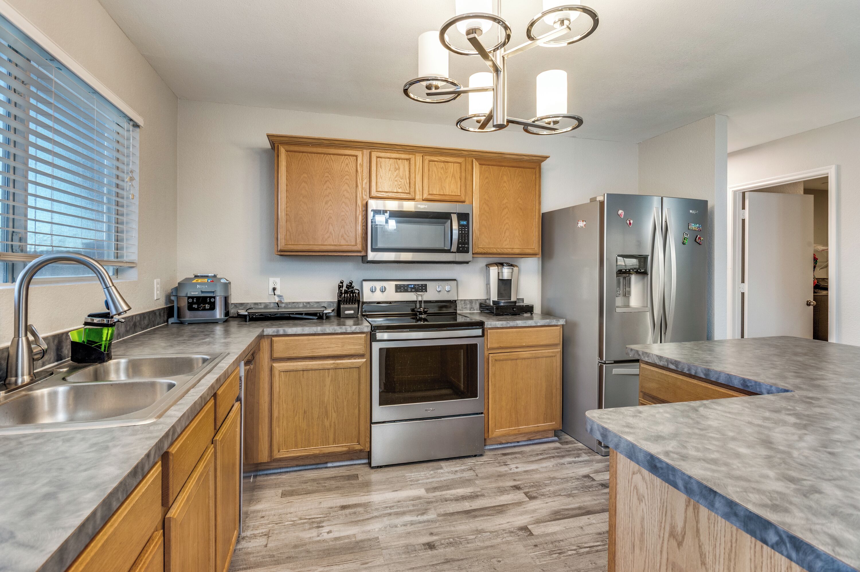 A modern kitchen with wooden cabinets, stainless steel appliances, and a built-in oven.