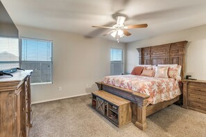 A bedroom with a bed, a desk, a ceiling fan, and a window with blinds. - Adorable 3-bedroom house with AC in charming Venus (Venus)