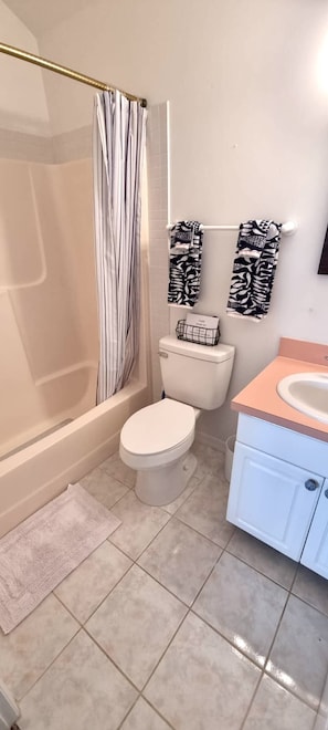A bathroom with a shower, toilet, and sink. - Beautiful Oceanfront 2-bedroom condo (Little Cayman)
