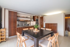 Une cuisine moderne avec des meubles en bois, un îlot central et un coin repas avec des chaises.