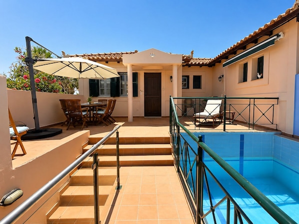 A rooftop pool area with a dining set and lounge chairs. - Private Methoni 3 Bedroom Villa Walk to Castle and Beach. (methoni)