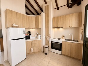 Une cuisine moderne avec des meubles en bois, un réfrigérateur blanc, une cuisinière et un évier.