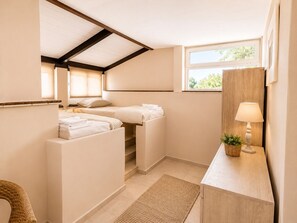 A compact hotel room with a loft bed, a small desk with a lamp, and a window with a view of trees. - Private Methoni 3 Bedroom Villa Walk to Castle and Beach. (methoni)