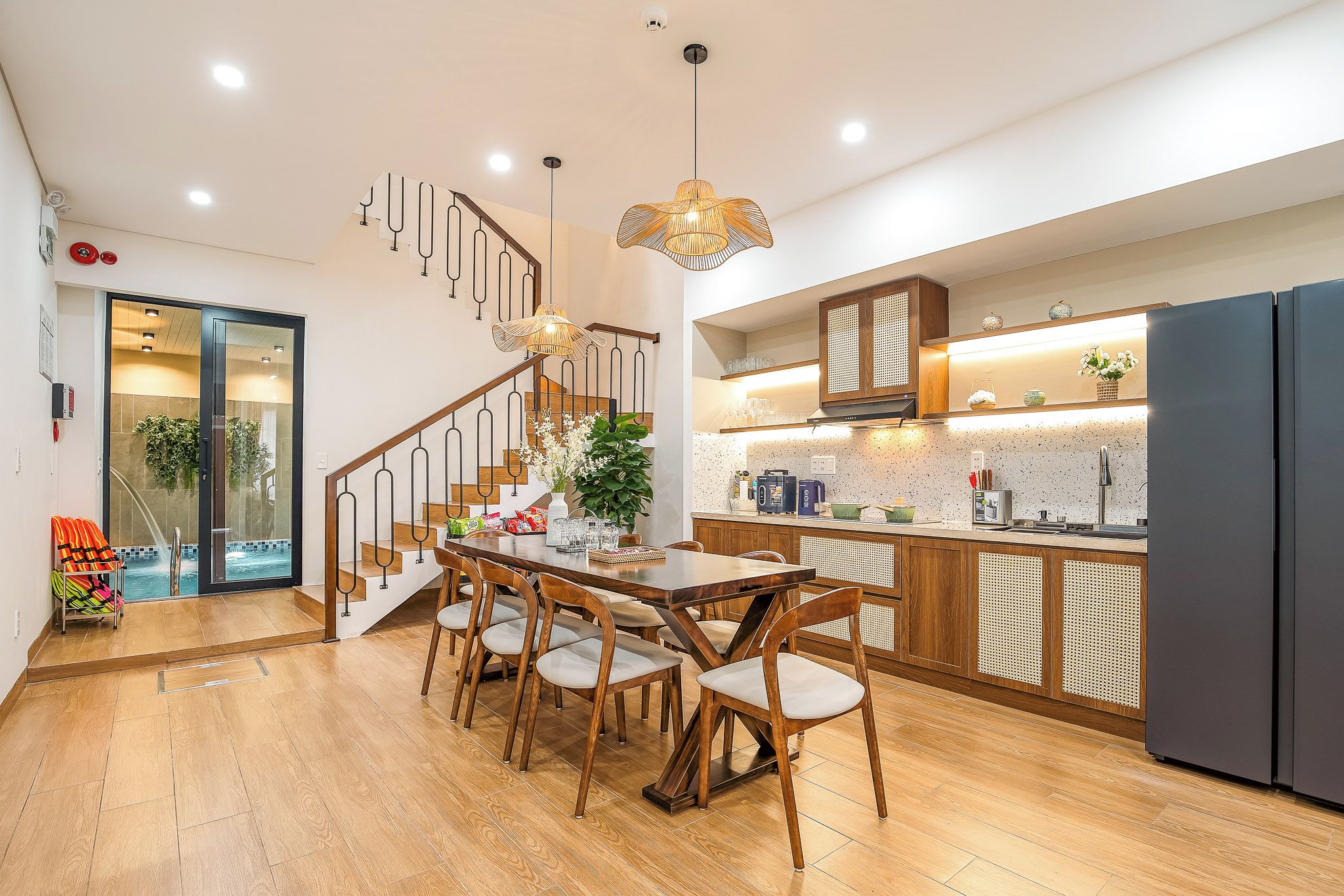 A modern kitchen with wooden cabinets, a built-in stove, and a large refrigerator.