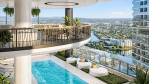 Un espace piscine aménagé sur le toit, offrant une vue sur le paysage urbain, entouré de verdure et doté de mobilier moderne.