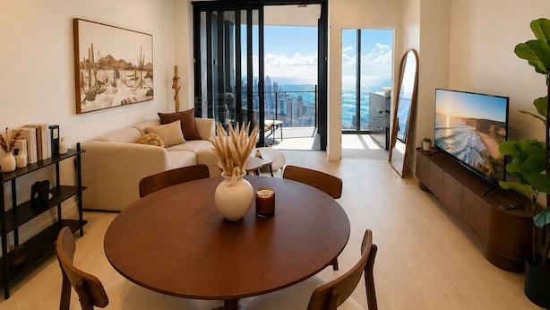 Un salon moderne comprenant un coin repas, un ensemble de canapés, un téléviseur à écran plat et une grande fenêtre donnant sur la ville.
