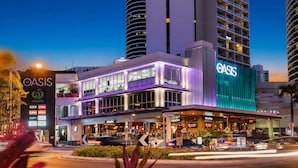 Un hôtel reconnaissable à son grand panneau « OASIS », avec de nombreux étages et un restaurant situé au rez-de-chaussée.