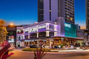 A hotel with a prominent 'OASIS' sign, multiple floors, and a ground-level restaurant. - Horizon Haven - Panoramic Ocean Views (Broadbeach)