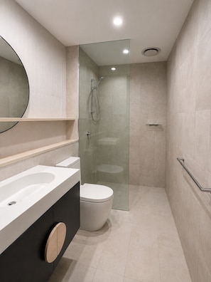 A modern bathroom with a glass-enclosed shower, a white sink, and a toilet. - Horizon Haven - Panoramic Ocean Views (Broadbeach)