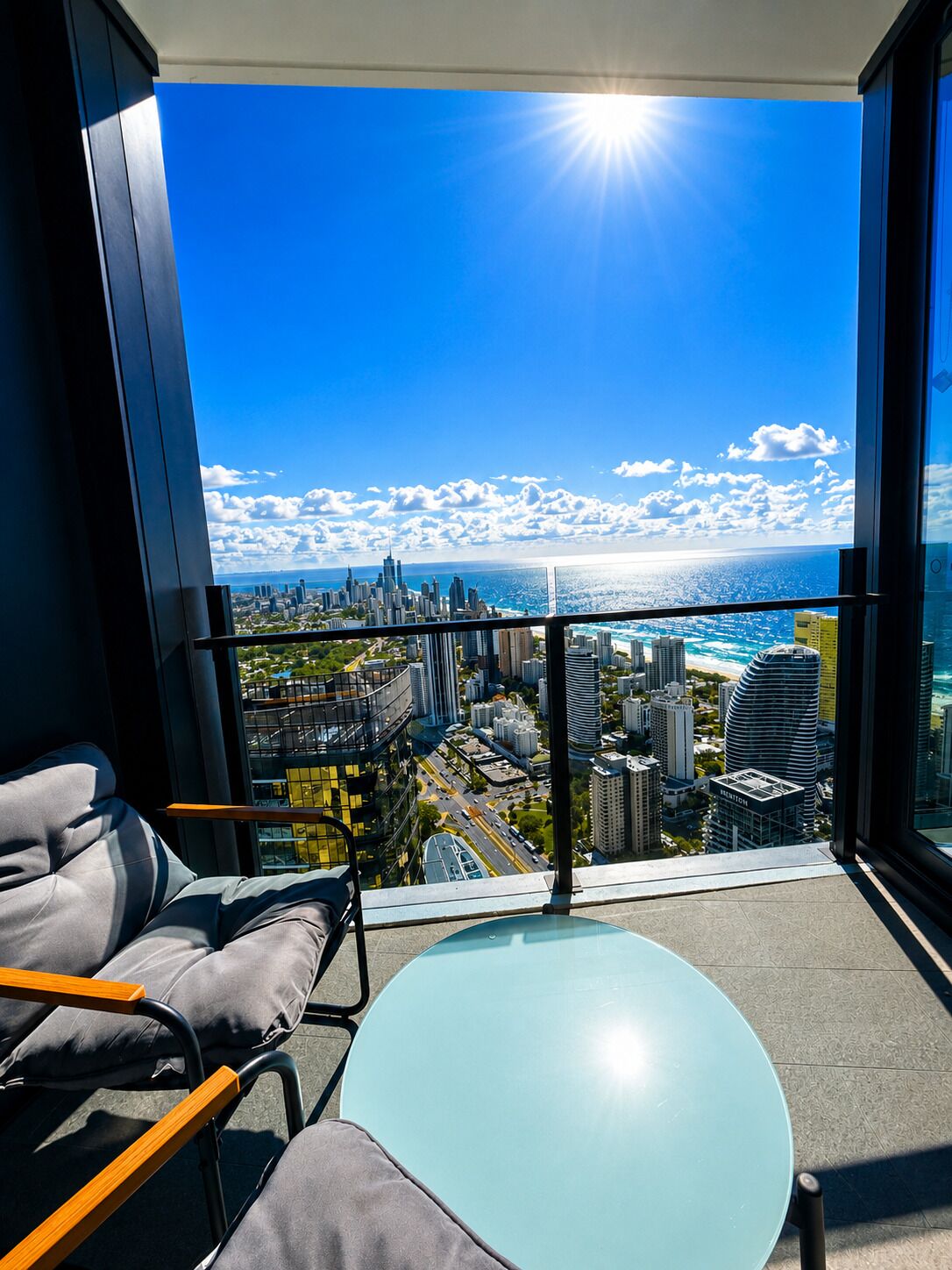 A balcony with a city view, a table, and a chair.