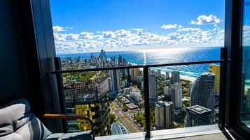 A balcony with a city view, a table, and a chair.